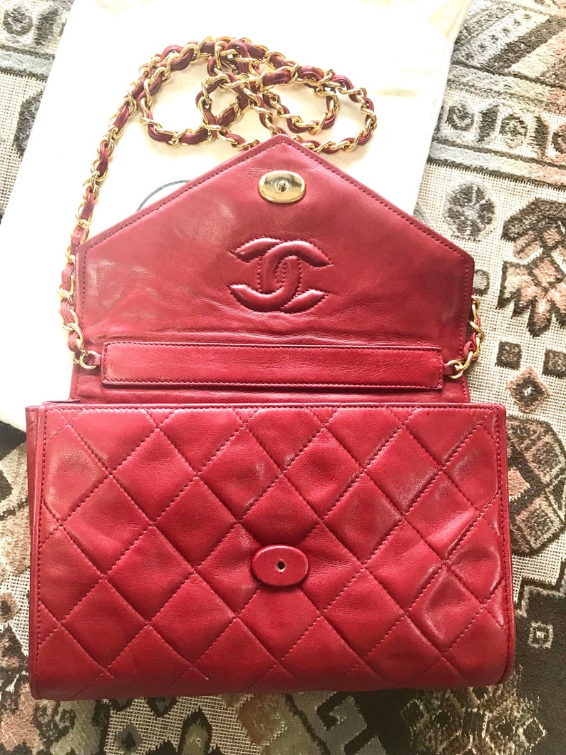 CHANEL Vintage red lamb leather shoulder bag with golden CC button motifs at flap