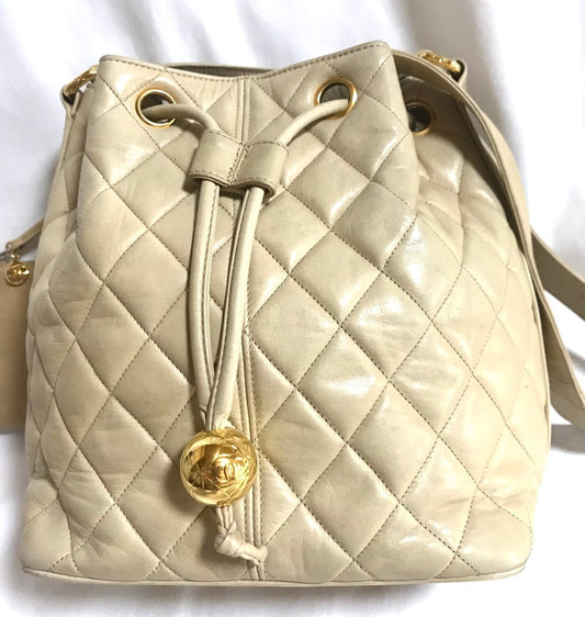 Luxury Chanel Vintage beige quilted lamb leather hobo bucket shoulder bag with drawstrings and golden CC mark ball