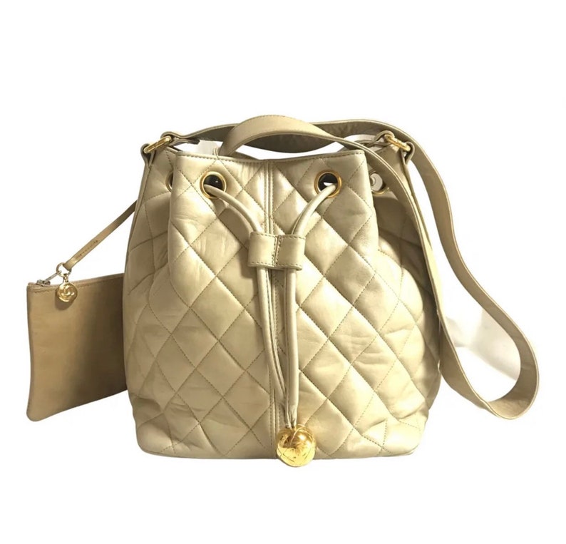 Luxury Chanel Vintage beige quilted lamb leather hobo bucket shoulder bag with drawstrings and golden CC mark ball